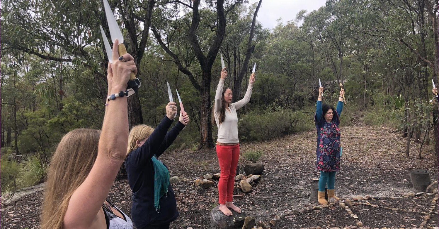 Four practitioners standing in a circle among trees, each raising a Selenite Sword of Light above their head