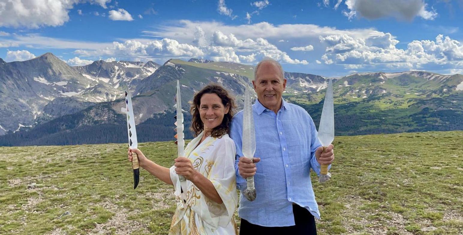 Tom Ledder and Maryke Love standing on a high mountain ridge in Colorado, each holding two Selenite Swords of Light